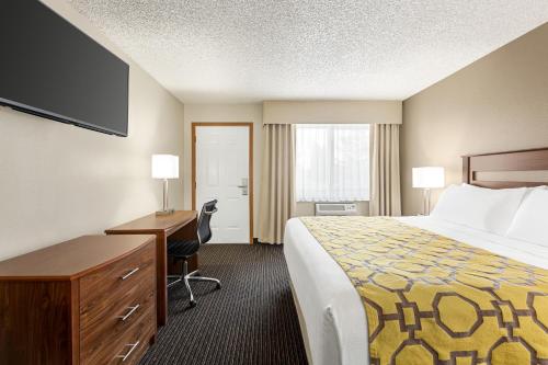 a hotel room with a bed and a desk and a computer at Baymont by Wyndham Whitefish in Whitefish