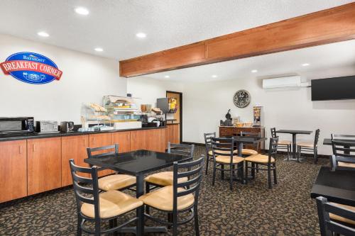 a dining room with tables and chairs and a counter at Baymont by Wyndham Whitefish in Whitefish