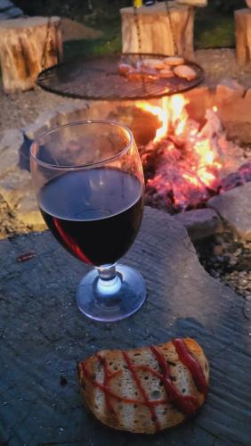 a glass of wine sitting next to a fire at Hytte Na Wyspie -,,Roztoczańskie Morze'' in Kulików