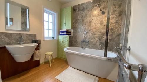 a bathroom with a bath tub and a sink at Ingledene a Spacious Family House in Bournemouth
