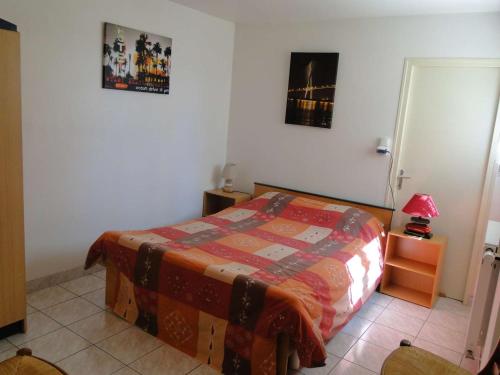 une chambre avec un lit, une table et une lampe dans l'établissement Gîte Orchidée, aux Herbiers