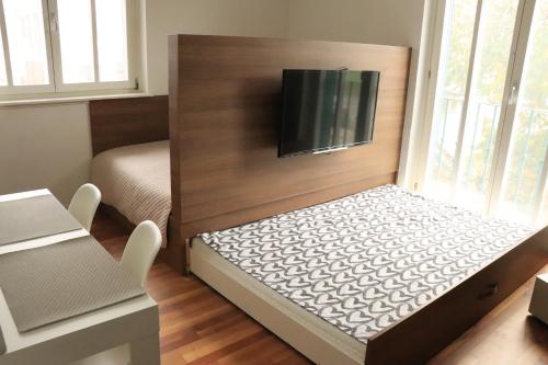 Habitación pequeña con cama y TV de pantalla plana. en Studio apartma Terme Ptuj en Ptuj