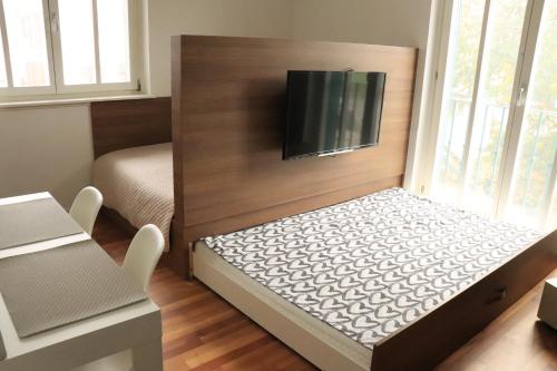 een kleine kamer met een bed en een flatscreen-tv bij Studio apartma Terme Ptuj in Ptuj