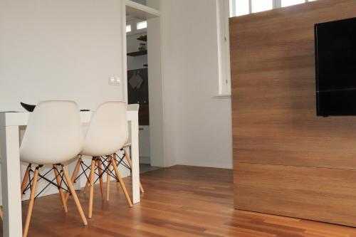 a living room with a table and two white chairs at Studio apartma Terme Ptuj in Ptuj
