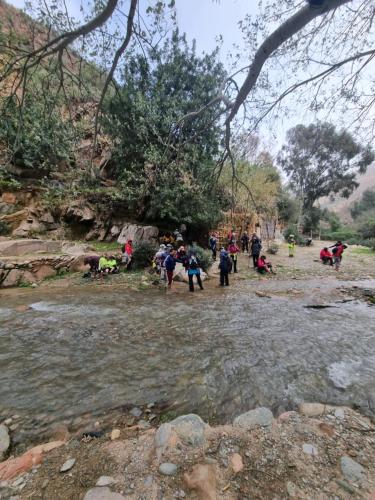 a group of people walking across a river at L'oliveraie D'amizmiz in Amizmiz