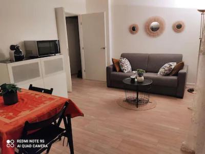 a living room with a couch and a table at Cosy Stay in Saint-Germain-en-Laye