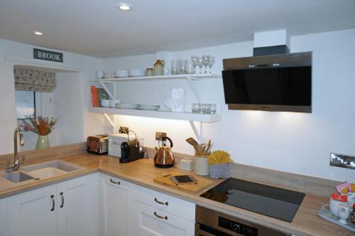 a kitchen with a counter top with a sink and a microwave at Brook Cottage Askrigg in Askrigg