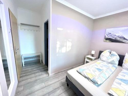 a small bedroom with a bed and a hallway at Pension Maier in Villach