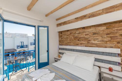 a bedroom with a bed and a brick wall at Agios Prokopios Hotel in Agios Prokopios