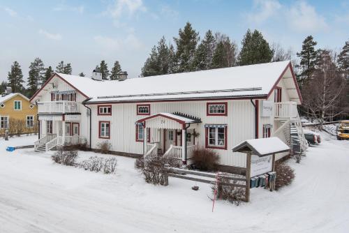 a large white house with snow on the ground at Bograngen LGH D in Brograngen