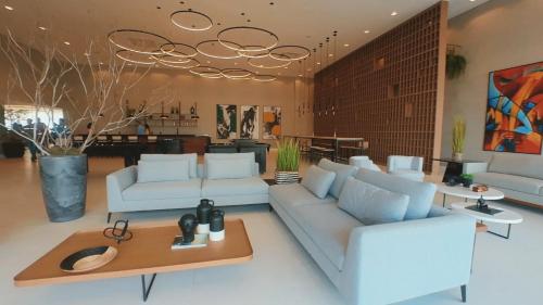 uma sala de estar com sofás brancos e uma mesa em Açu Hotel em São João da Barra