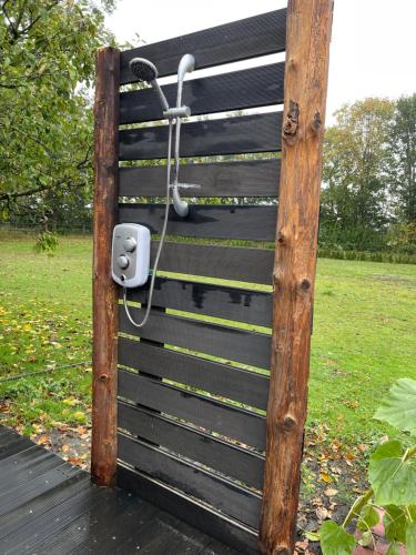 une porte en bois avec une balançoire dans un parc dans l'établissement Hipsy-Gipsy saunalodge, à Heede