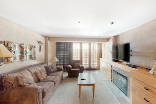 a living room with a couch and a flat screen tv at Shoshone 1930 in Big Sky