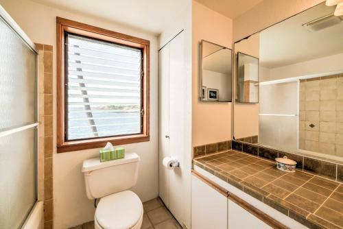 baño con aseo y ducha y ventana en Oceanfront Kailua-Kona Townhome with Pool and Views!, en Kailua-Kona