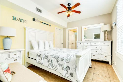 a bedroom with a bed and a ceiling fan at Galveston Beach Getaway #1 in Galveston