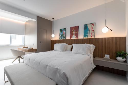 um quarto com uma grande cama branca e uma secretária em Agradável em Ipanema - 2 suites completas - J303 Z2 no Rio de Janeiro