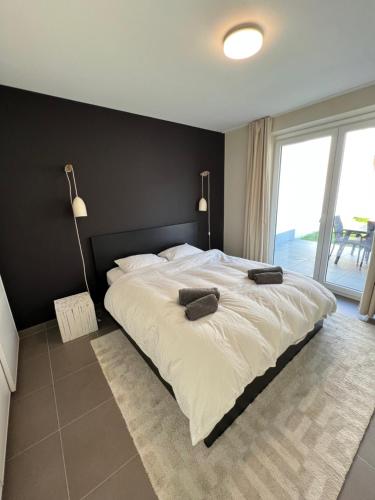 a bedroom with a large bed with a black wall at Beautiful 3 bedroom garden-appartment near Knokke-Strand Beach Bar in Knokke-Heist