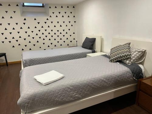 sypialnia z 2 łóżkami i ścianą z trójkątami w obiekcie Invicta House Gold w Porto