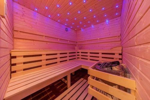 a wooden sauna with a bench and purple lights at Chalupa Lilien pod Medvědí skálou Jeseníky in Jindřichov