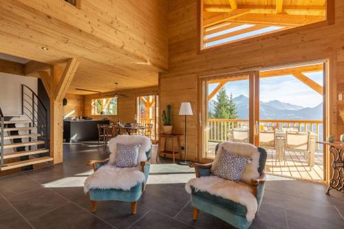 a living room with two chairs and a view of the mountains at Chalet "Lucyvon" exceptional view in Manigod