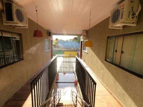 um corredor vazio de um edifício com escadas e luzes em Rodrigo Hostel Suítes em Bonito
