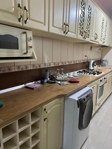 a kitchen with white cabinets and a washer at Casa Bia in Iaşi