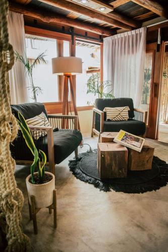 a living room with two chairs and a coffee table at Aldea Kuká, Luxury Eco Boutique Hotel in Holbox Island