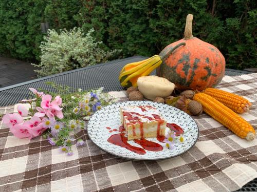 a piece of cake on a table with vegetables and a pumpkin at Villa Mukinja - Wellness & Spa in Plitvička Jezera
