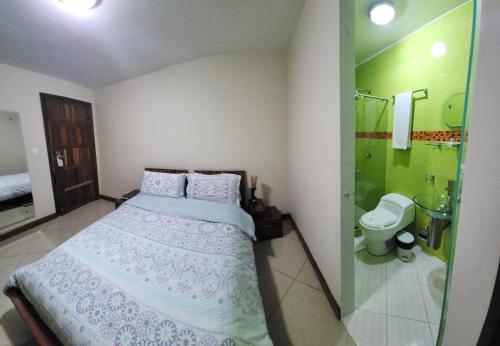 a bedroom with a bed and a shower and a toilet at Apartahotel Vincent Suites in Pasto