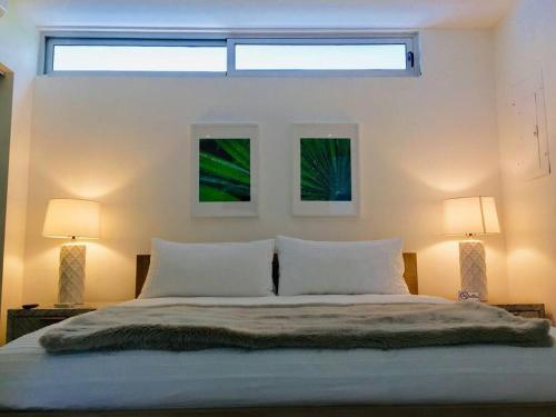 1 dormitorio con 1 cama grande y 2 lámparas en Casa Moderna Fresca and The PoolClub at Mahogany Bay! en San Pedro