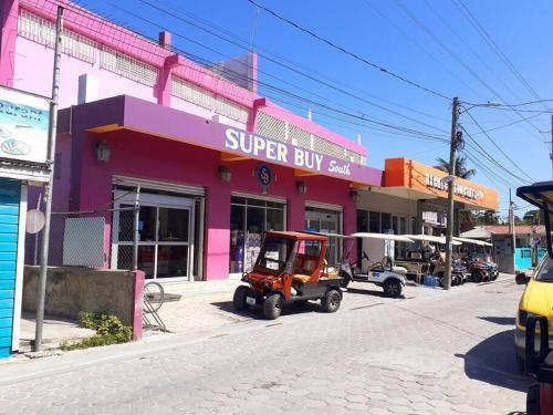 a small golf cart parked in front of a store at Casa Moderna Fresca and The PoolClub at Mahogany Bay! in San Pedro