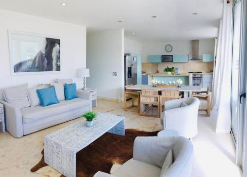 a living room with a couch and chairs and a table at Casa Moderna Fresca and The PoolClub at Mahogany Bay! in San Pedro
