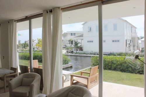 a living room with a large window with a view of the water at Casa Moderna Fresca and The PoolClub at Mahogany Bay! in San Pedro