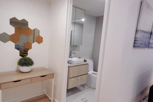 a bathroom with a sink and a toilet in it at Cozy 1BR Apartment in the heart of Canberra in Canberra