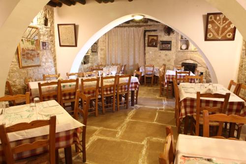 a dining room with tables and chairs and an archway at Agrovino Lofou in Lofou