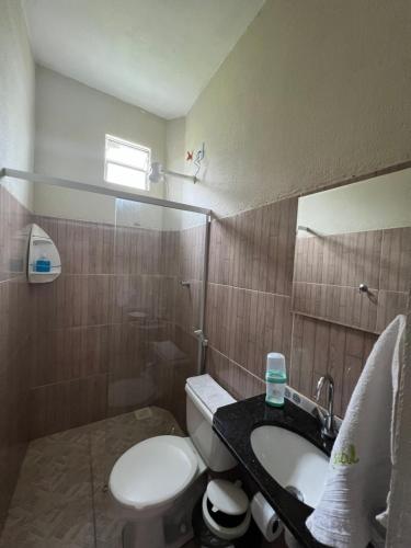 a bathroom with a white toilet and a sink at Pousada da Celma in Fortaleza
