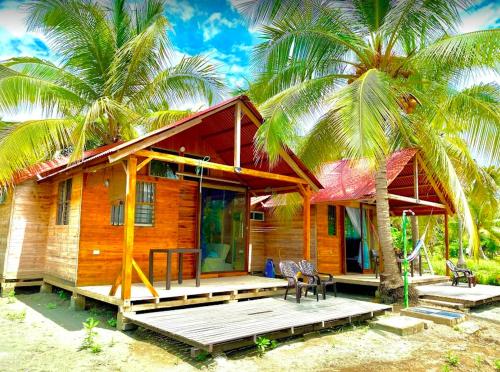 ein Haus am Strand mit zwei Palmen in der Unterkunft Cabañas Estrella de Mar, Palmar del viento, Moñitos in Moñitos