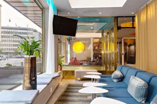 a living room with a blue couch and tables at Best Western Hotel Fridhemsplan in Stockholm