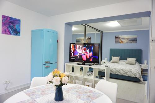 a room with a table and a tv and a bed at Studio'24 - Tomis Mall - Ultracentral in Constanţa