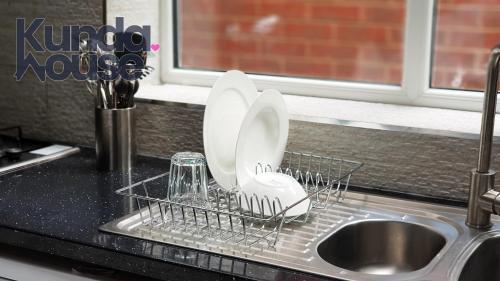 two dishes in a dish rack next to a sink at Kunda House Bournbrook in Birmingham
