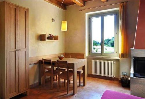 a dining room with a table and chairs and a window at Country House Casco Dell'Acqua in Trevi