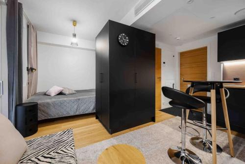 1 dormitorio con cama, escritorio y mesa en Sari’s luxury studio in the city center en Turku