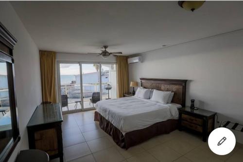 1 dormitorio con cama y ventana grande en Sand Bar Condo - 1BR Suite next to The Morgan Resort, en Maho Reef