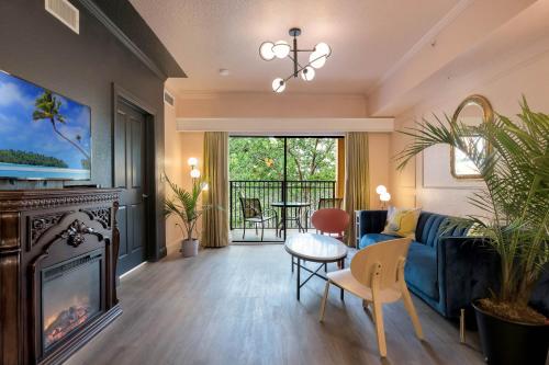 a living room with a blue couch and a fireplace at Designer 3BR/2BA Corner Suite - Disney & Universal in Orlando