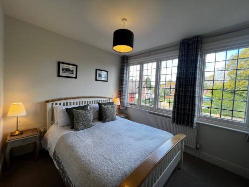 a bedroom with a bed and two windows at White Hart in Alton