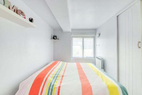 um quarto com uma cama com um cobertor colorido em appartement tout équipé avec terrasse et parking privé em Brétigny-sur-Orge