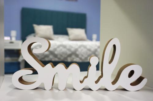 a white sign that says love in front of a bedroom at Studio'24 - Tomis Mall - Ultracentral in Constanţa