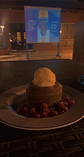a piece of cake on a plate on a table at فندق ادوماتو ADOMATo HOTEl in Dawmat al Jandal