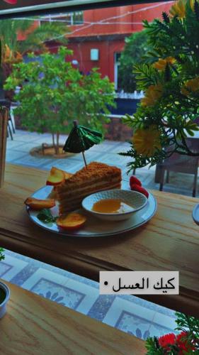 a plate of food sitting on a wooden table at فندق ادوماتو ADOMATo HOTEl in Dawmat al Jandal