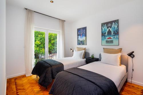 2 letti in una camera con finestra di WHome Prime Location w AC 3-Bed Duplex Perfect for Families ONLY a Lisbona